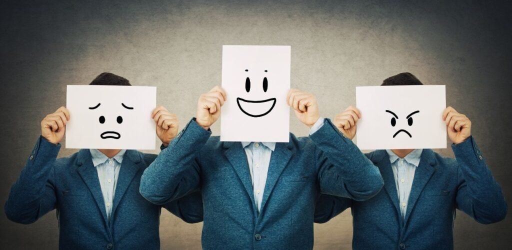 Homem bipolar no relacionamento ilustrado por três figuras idênticas vestindo terno azul, cada uma segurando uma folha com rosto desenhado — um triste, um feliz e um irritado — simbolizando as oscilações de humor típicas do transtorno bipolar.