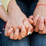 Pessoa com câncer segurando a mão de um familiar ou cuidador, simbolizando apoio emocional, proximidade e acolhimento durante o tratamento