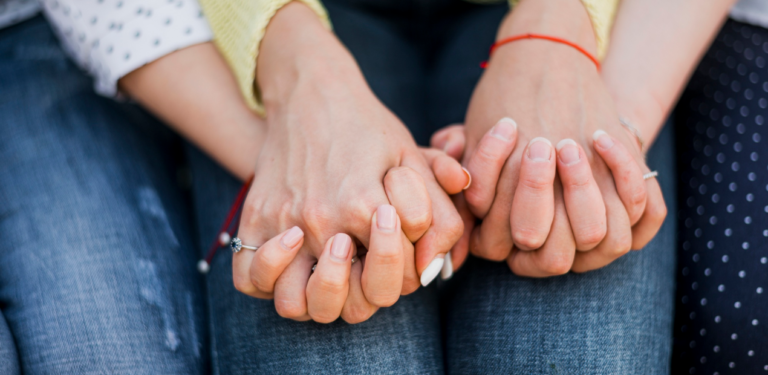 Pessoa com câncer segurando a mão de um familiar ou cuidador, simbolizando apoio emocional, proximidade e acolhimento durante o tratamento