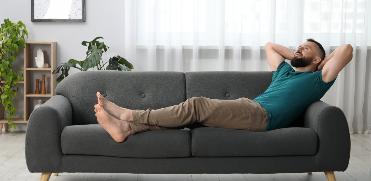 Homem relaxando no sofá em ambiente residencial que transmite conforto e bem-estar psicológico