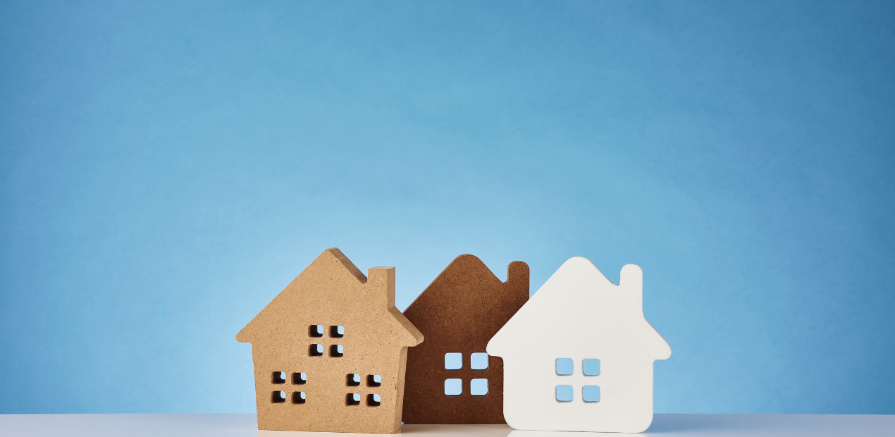 Casas decorativas em tons neutros simbolizando diferentes estilos de moradia e bem-estar psicológico