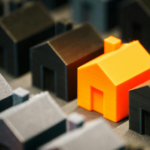 Casas em miniatura com uma residência em destaque, simbolizando a escolha consciente do ambiente e seu impacto na saúde mental