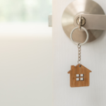 Chaveiro em formato de casa pendurado na maçaneta simbolizando o lar como espaço de equilíbrio emocional e saúde mental