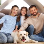 Família sentada no chão da sala com um cachorro, simbolizando o lar como espaço de segurança emocional e bem-estar mental