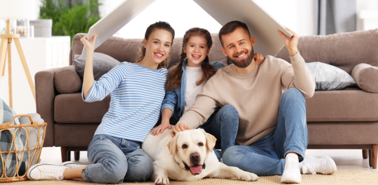 Família sentada no chão da sala com um cachorro, simbolizando o lar como espaço de segurança emocional e bem-estar mental