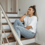Mulher sentada na escada, representando medo de mudar de cidade