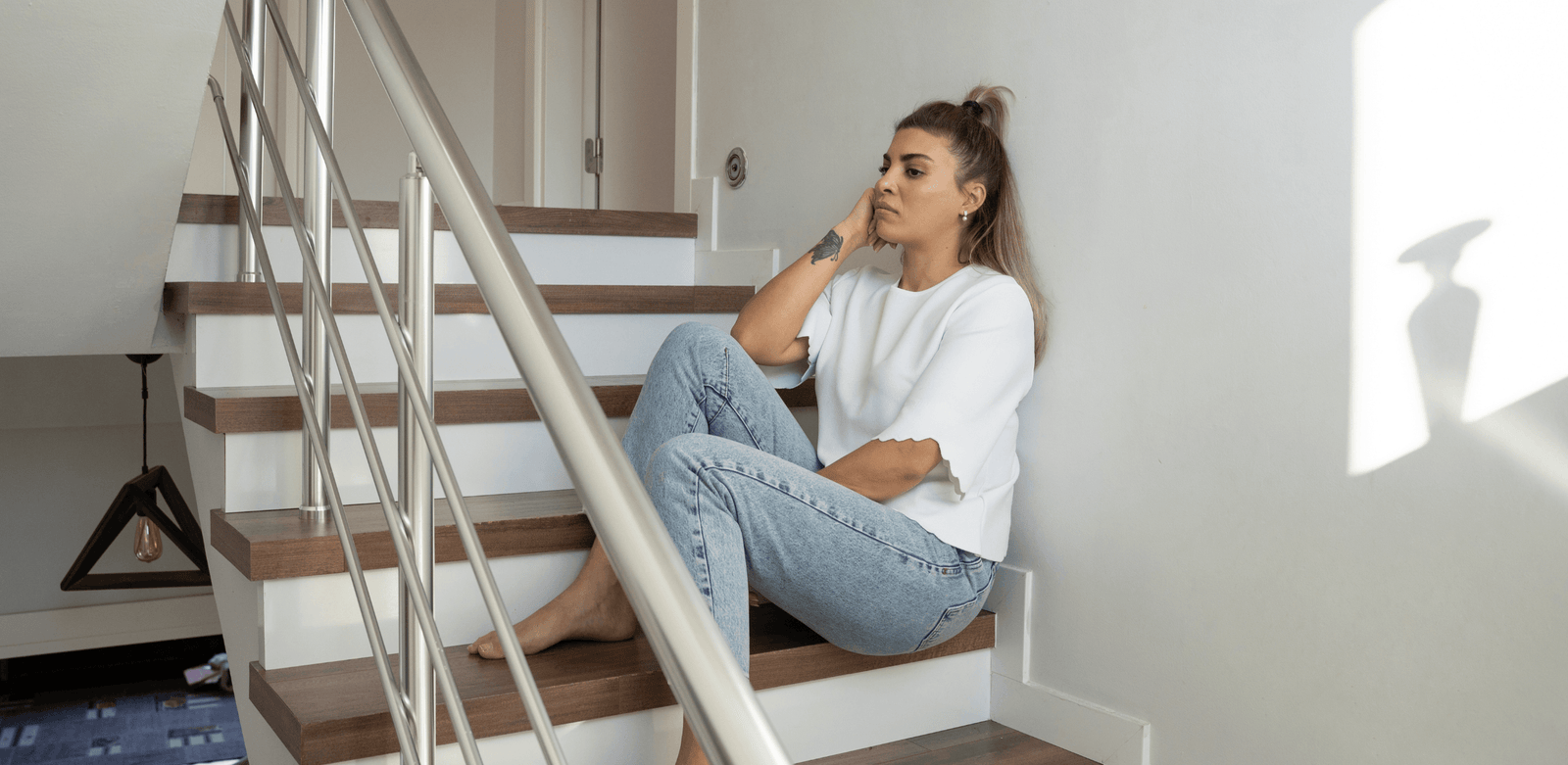 Mulher sentada na escada, representando medo de mudar de cidade