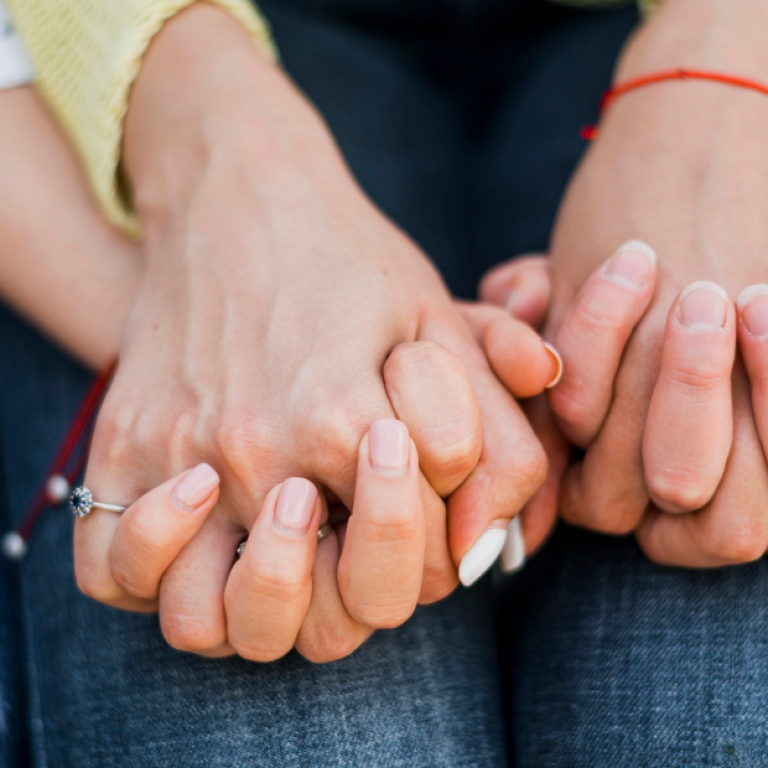 Pessoa com câncer segurando a mão de um familiar ou cuidador, simbolizando apoio emocional, proximidade e acolhimento durante o tratamento