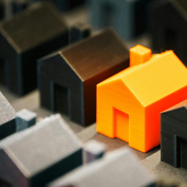 Casas em miniatura com uma residência em destaque, simbolizando a escolha consciente do ambiente e seu impacto na saúde mental