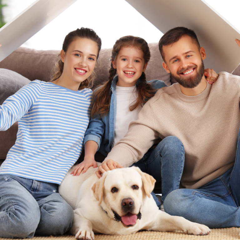 Família sentada no chão da sala com um cachorro, simbolizando o lar como espaço de segurança emocional e bem-estar mental