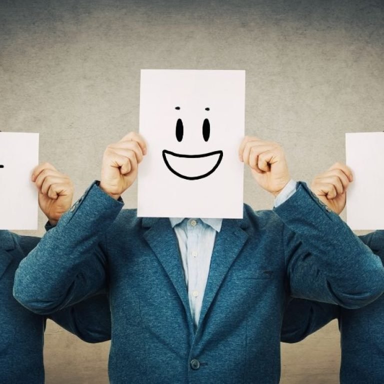 Homem bipolar no relacionamento ilustrado por três figuras idênticas vestindo terno azul, cada uma segurando uma folha com rosto desenhado — um triste, um feliz e um irritado — simbolizando as oscilações de humor típicas do transtorno bipolar.